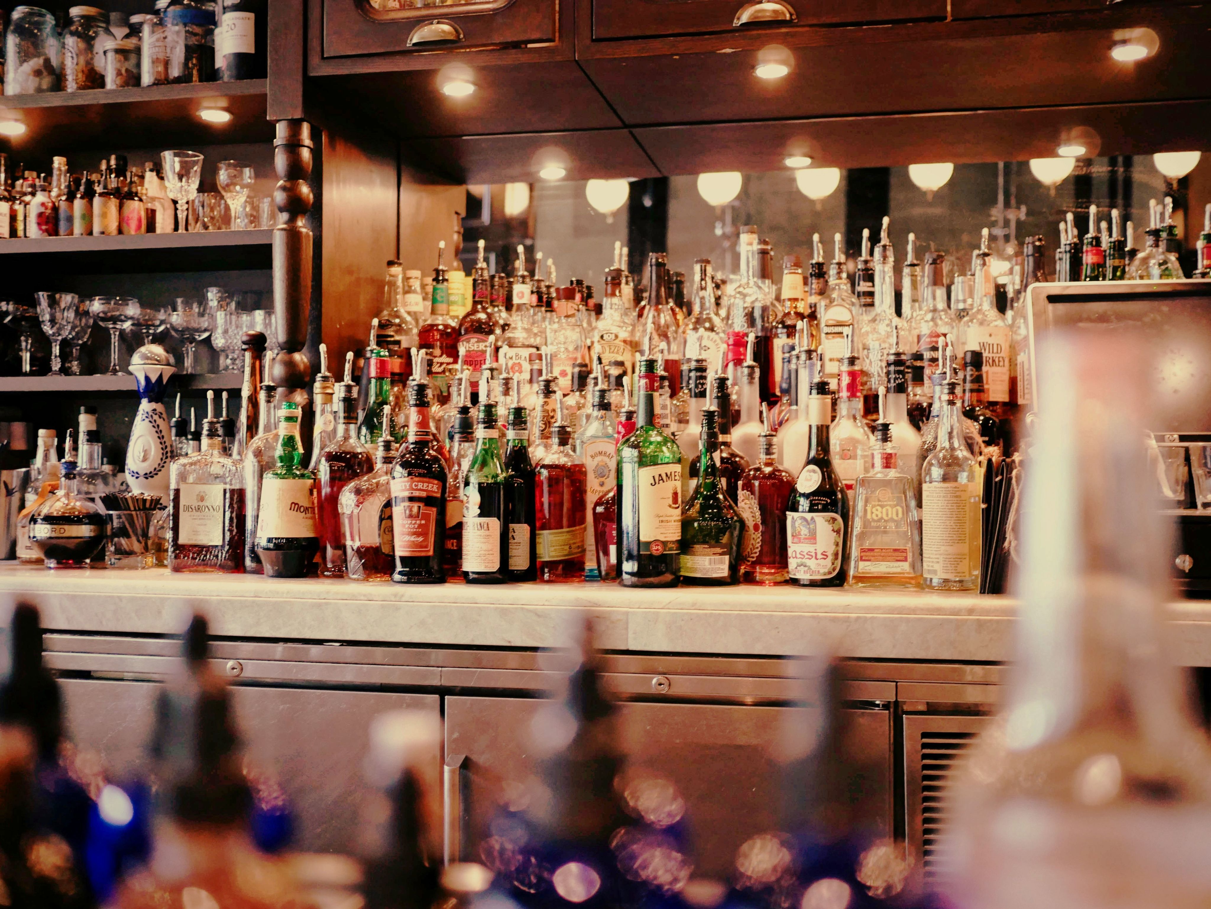 liquor bottles on white and brown wooden cabinet